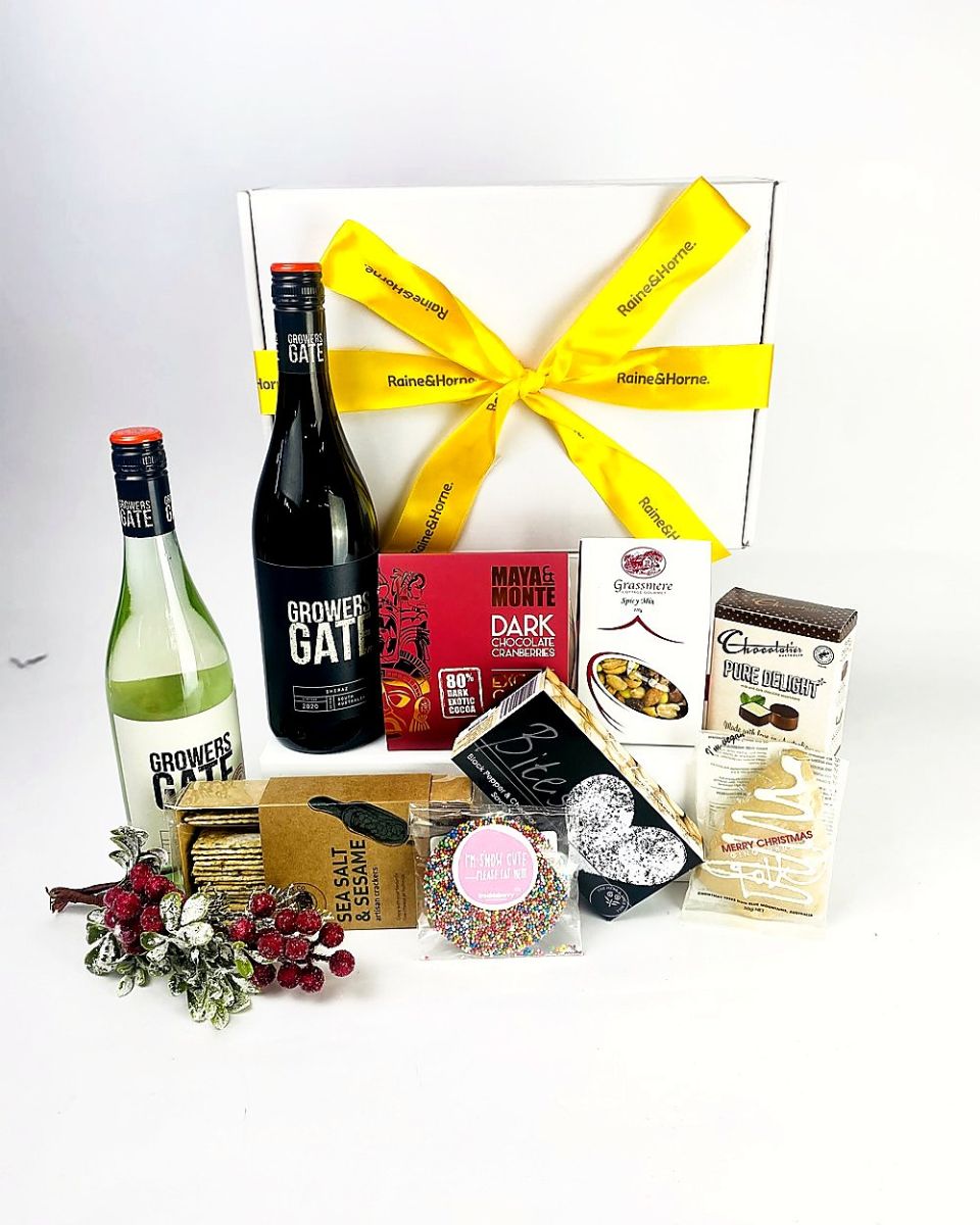 Wine and gourmet hamper with a branded yellow ribbon on a white gift box